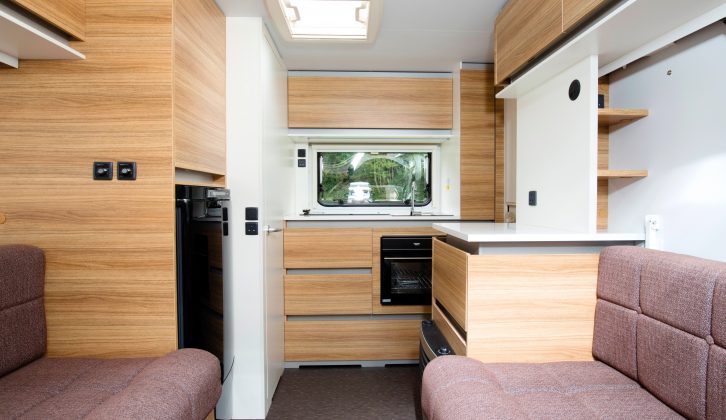 The sideboard by the entrance door can prove useful as a back-up food-preparation area, and the shelves above it hide the TV connection point