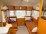 The comfortable lounge of this vintage caravan makes up into a double bed, with a fold-out bunk above