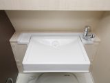 The washbasin can be folded up to access the bench-style toilet