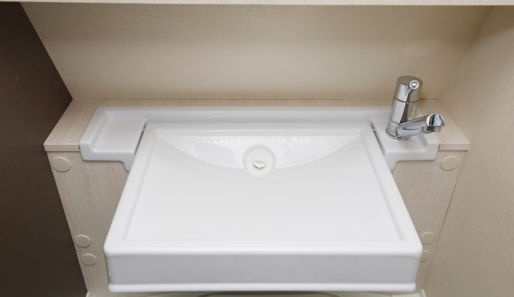 The washbasin can be folded up to access the bench-style toilet