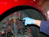 Remove the wheel nuts and wheel, then undo the upper shock-absorber mounting bolts