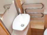 A salad-bowl washbasin sits next to a heated towel rail in the central washroom of this Elddis caravan