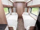 The rear fixed single beds are 1.91m long and 0.66m wide, each with a large window, a padded headboard, a shelf and a reading light