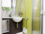 The compact washroom has eye-catching lime-green walls and packs an Ecocamel showerhead