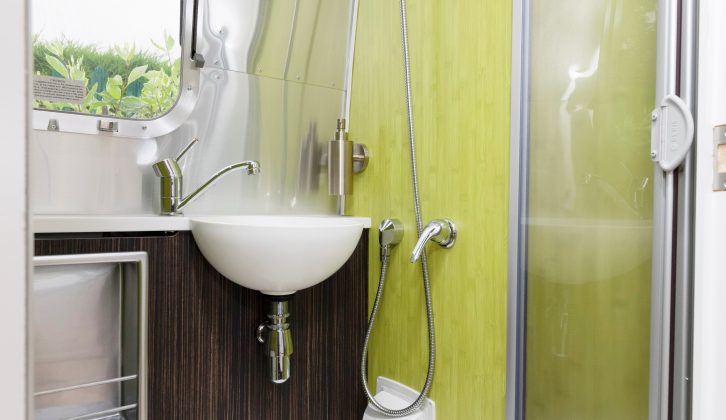 The compact washroom has eye-catching lime-green walls and packs an Ecocamel showerhead