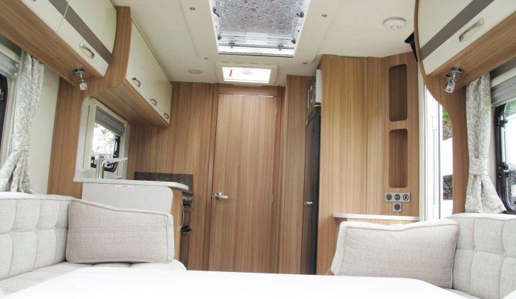 The warm wood tone complements the light walls, worktop and furnishings very well, and this van features a large rooflight, a trademark of Lunar caravans
