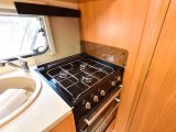 The hob has three gas burners (the hob and oven here looked unused) and the granite-effect sink has a clip-on drainer