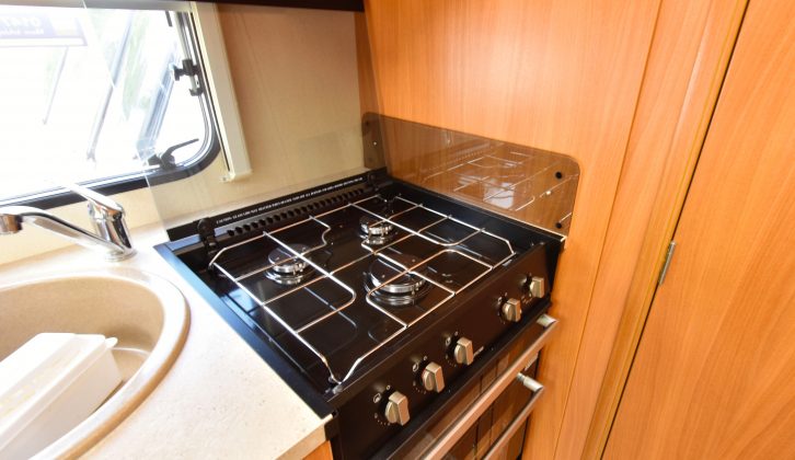 The hob has three gas burners (the hob and oven here looked unused) and the granite-effect sink has a clip-on drainer