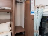 Wardrobes flank the double bed and the domestic-style curtains help create a cosseting atmosphere