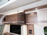 As you'd expect in a luxury caravan, a glass-fronted cocktail cabinet sits alongside three other overhead kitchen cupboards