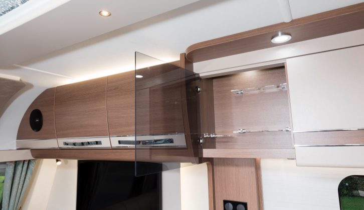 As you'd expect in a luxury caravan, a glass-fronted cocktail cabinet sits alongside three other overhead kitchen cupboards