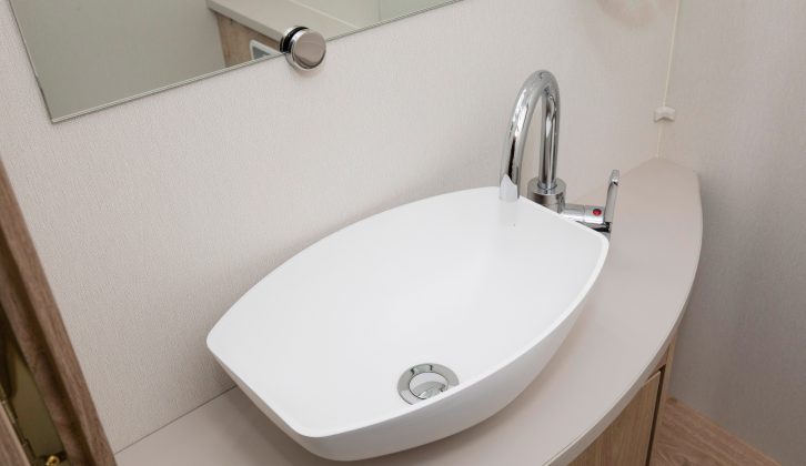There's a contemporary feel to the washroom where this swan neck mixer tap stands over the elegant basin