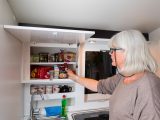 That white-fronted cupboard has a single door and is shelved – read more in the Practical Caravan Adria Action 361 LT review
