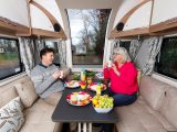 The central window makes the lounge airy and bright, while muted mushroom and blue upholstery, and white locker facings, add to the feeling of spaciousness