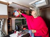 Behind a long, single cupboard door, is a good amount of overhead storage, with racking on the left and shelving on the right