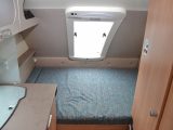 The 1.94 x 1.42m fixed double bed has headboards either end and is lit by the large slit window