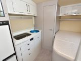 The offside kitchen is opposite the fixed double bed – the sink has blue protective cellophane covering it in our photos
