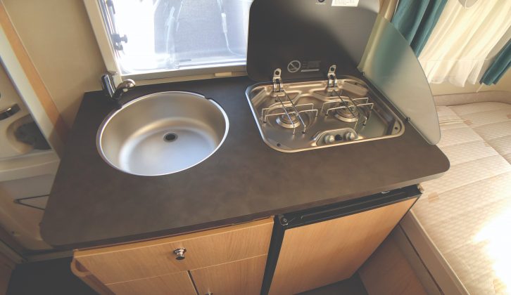 The galley in the Eriba Touring Troll 530 '60 Edition' comprises a circular sink, hob with two gas burners, 70-litre fridge, cutlery drawer and cupboard. The work surface has a fingerprint-resistant finish