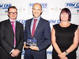 BMW's Brian Cox returns to the stage to collect the award for Tow Car of the Year - the BMW 5 Series Touring - at the Tow Car Awards 2018, from Practical Caravan's editor, Niall Hampton, and Sabina Voysey from the Camping and Caravanning Club