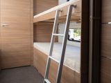 Opposite, the fixed bunk beds come with a ladder, and the whole area can be separated from the lounge by a screen