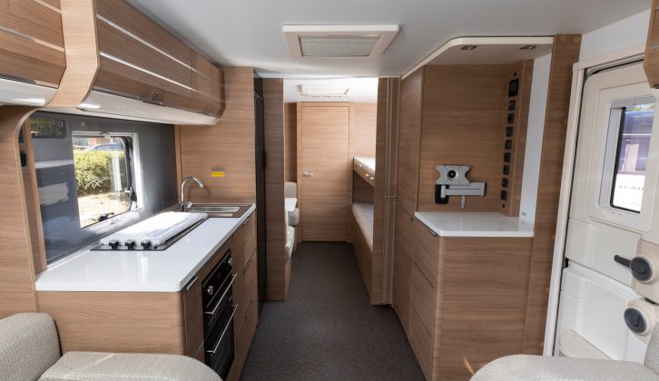 The layout features a central kitchen between the front lounge and the bunks