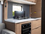 The generous kitchen features a three-burner hob and separate oven and grill, plus a microwave hidden in the overhead cupboard