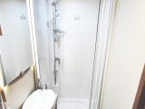 The washroom has a fully lined shower cubicle and large handbasin