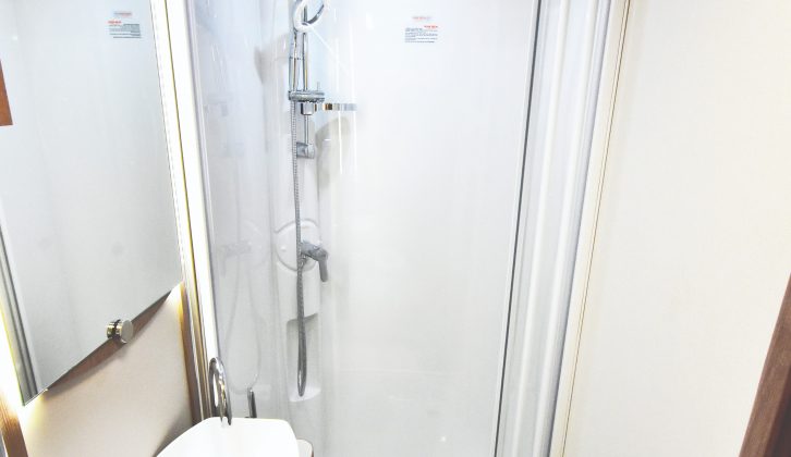 The washroom has a fully lined shower cubicle and large handbasin