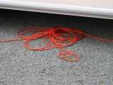 Completely unwind the hook-up cable to avoid any risk of it overheating and possibly catching fire, and place it carefully underneath the caravan
