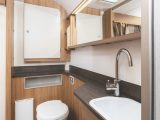 There is a spacious washroom with smart handbasin, swan-neck tap and lots of cupboard space