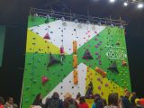 You'll find the climbing wall at the back of Hall 4, by the stylish glamping village