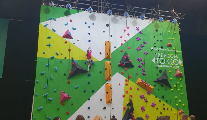 You'll find the climbing wall at the back of Hall 4, by the stylish glamping village