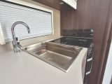 There is a large rectangular sink and dual-fuel hob in the well-equipped kitchen