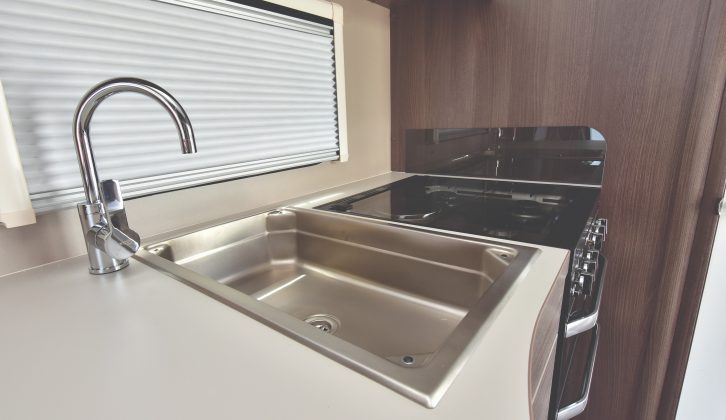 There is a large rectangular sink and dual-fuel hob in the well-equipped kitchen
