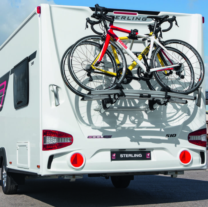 A bike rack on the rear of a caravan with two bikes attached