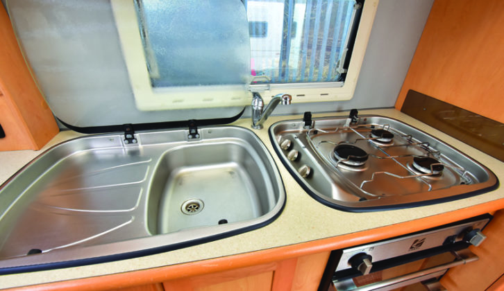 Side kitchen provides stainless-steel sink/drainer and three-burner gas hob