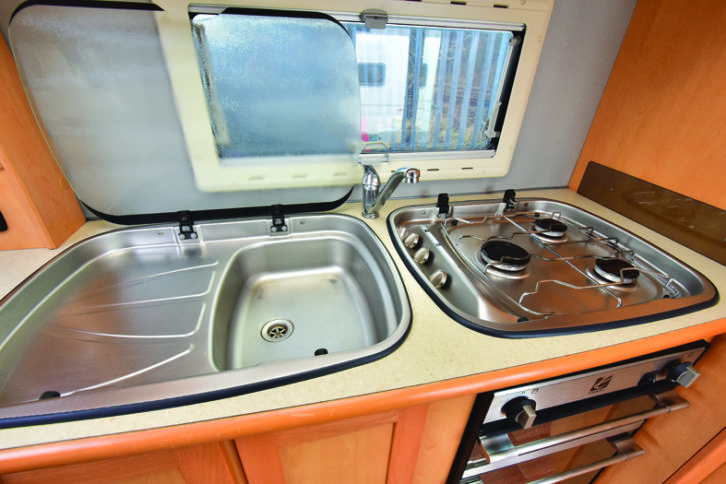 Side kitchen provides stainless-steel sink/drainer and three-burner gas hob