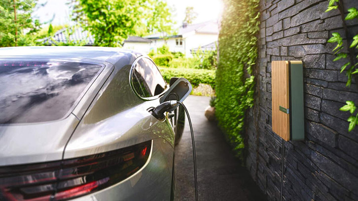 An electric vehicle at a wall-mounted charge point