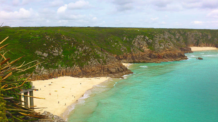 An aerial shot of a Cornish beach, with the sea, cliffs and sand all in view