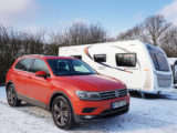 A VW and caravan parked with snow on the ground