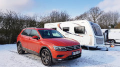 A VW and caravan parked with snow on the ground