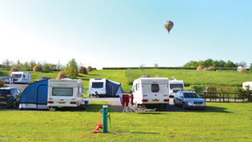 Caravns parked up with a hot air balloon in the background