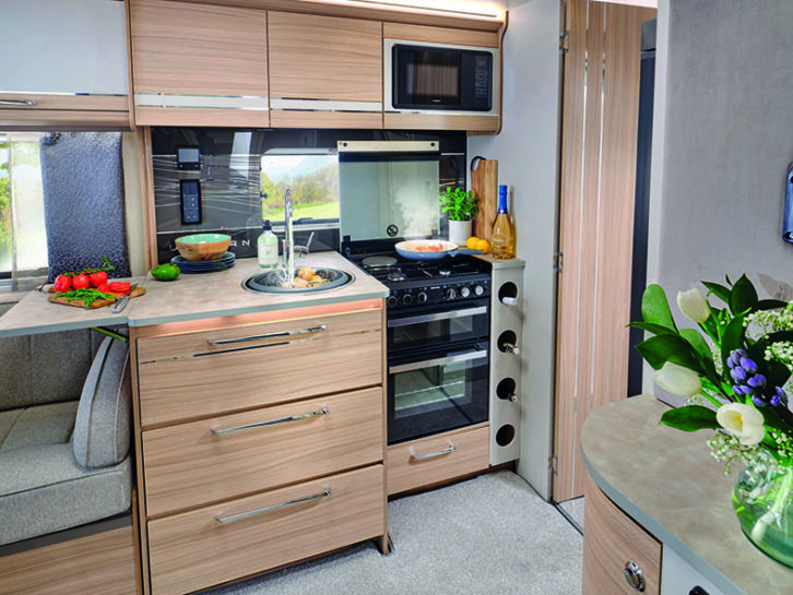 A smart splash back in the kitchen complements the overall colour scheme while deep drawers and cupboards offer ample storage