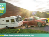 A caravan being towed against a scenic backdrop