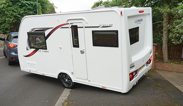 A rear view of the caravan being towed from the driveway