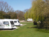 Two caravans pitched up on a campsite on a bright day