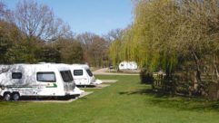 Two caravans pitched up on a campsite on a bright day