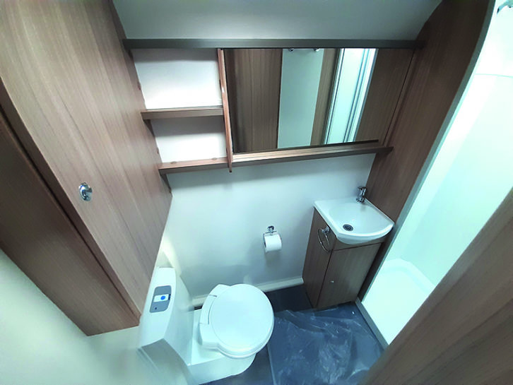 Washroom benefits from a large mirror, and a second roof light in the shower cubicle