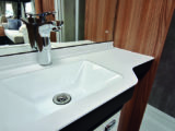 Smart handbasin in the washroom has a large mirror above and cupboard storage below