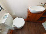 Washroom has a window, electric-flush toilet, further storage and a roof vent
